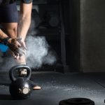 man powdering hands before lifting kettlebell in royalty free image 1613500859